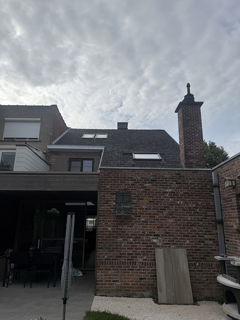 Voor de dakrenovatie in Aalst, met een verouderd en verkleurd pannendak.